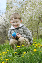 Boy with eastre egg among spring garden