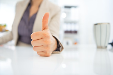 Closeup on business woman showing thumbs up