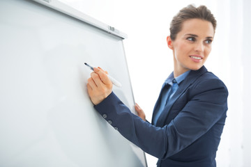 Closeup on business woman writing in flipchart
