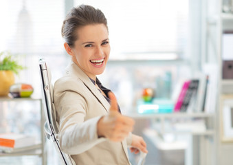 Happy business woman showing thumbs up