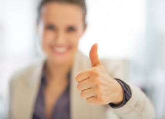 Closeup on smiling business woman showing thumbs up