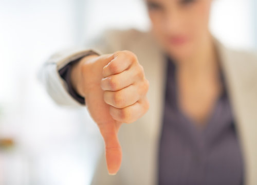 Closeup on business woman showing thumbs down