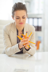 Business woman holding pencils