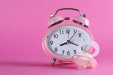 Pretty pink vintage retro alarm clock with baby dummy