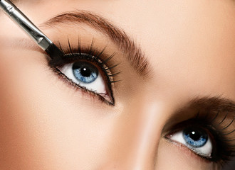 Makeup applying closeup. Eyeliner. Cosmetic eyeshadows