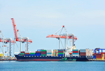 Container stack and ship under crane bridge