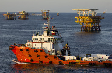 Oil rigs and a supply vessel