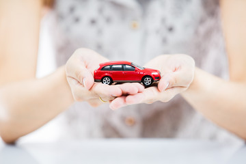 Woman hand with holding red car