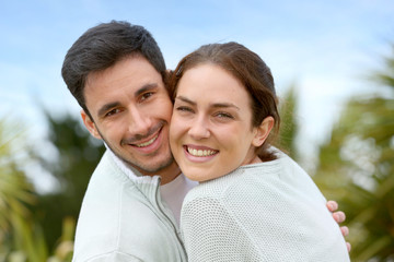 Couple embracing each other in front of house