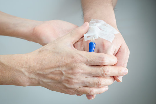 Mom hands holding her son hand with IV infusion device