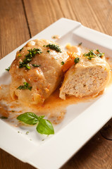 Closeup of stuffed cabbage rolls with tomato souce and herbs