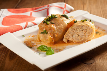Closeup of stuffed cabbage rolls with tomato souce and herbs