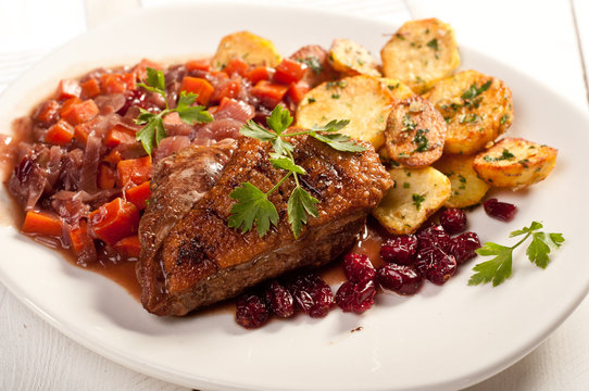 fillet of duck with roasted potatoes, vegetables and cranberry