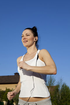 runner - woman running outdoors training for marathon run.