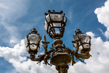 Fototapeta na wymiar Street Lantern on the Alexandre III Bridge against Cloudy Sky, P