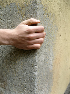 boy's hand on the edge of a wall