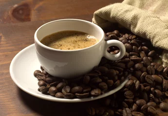 Kaffeetasse und Körner auf Holztisch