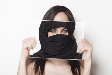 Girl holding a photo of herself wearing a burqa