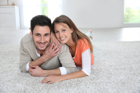 Couple laying on carpet of brand new renovated flat
