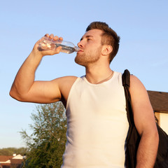 Thirsty athlete drinking water after workout