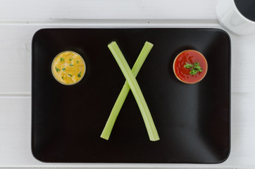 Vegetables with two dips on black plate