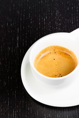 great italian coffee in a white cup on black wood table