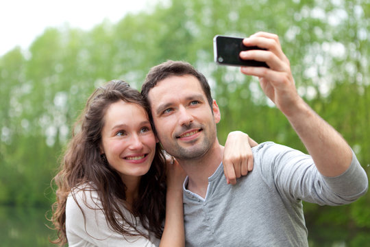 Young couple taking selfie picture at the park