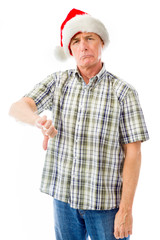 Senior man wearing Santa hat and making thumbs down gesture