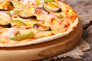 Detail of sea fruit pizza on the old table. horizontal.