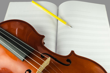 Fototapeta premium Closeup of violin, blank note sheet and pencil
