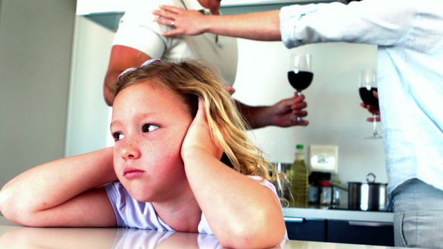 Little girl blocking out noise from parents fighting