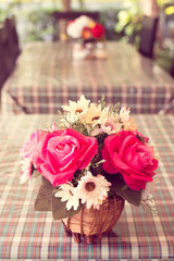 beautiful artificial roses on table with retro filter effect