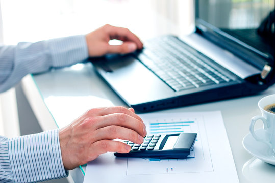 Businessman working at a computer. Composition with graph, calcu