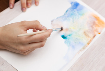 brush in the hands of the artist, watercolor painting, creativit
