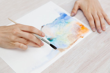 brush in the hands of the artist, watercolor painting, creativit
