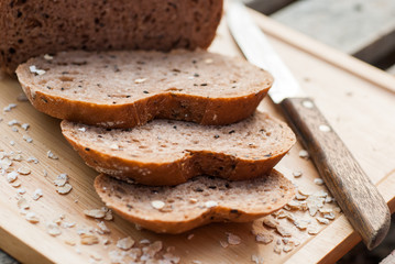 Several slices of Bread wheat and wooden chopping board