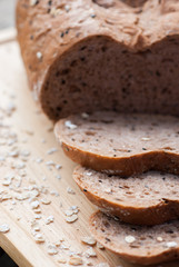 Several slices of Bread wheat and wooden chopping board