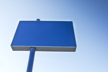 Blue billboard ready for new advertisement over blue sky