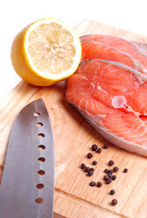 salmon with lemon on wooden board.