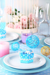 Table serving with colorful tableware on room background