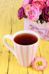 Fragrant tea with flowers on wooden table close-up