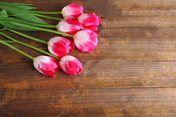 Obraz na płótnie Canvas Beautiful tulips on color wooden background