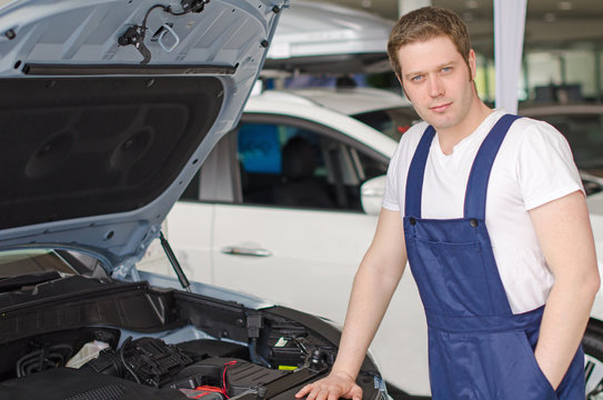 Young Handsome Mechanic Standing Near Open Car Hood