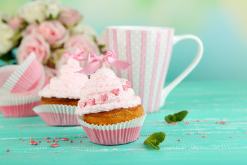 Tasty cup cakes with cream on blue wooden table