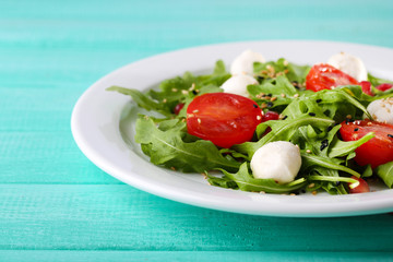 Green salad made with  arugula, tomatoes, cheese mozzarella