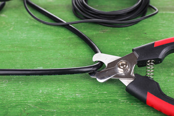 Side cutters cut cable on wooden background