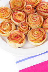 Obraz na płótnie Canvas Tasty puff pastry with apple shaped roses on plate close-up