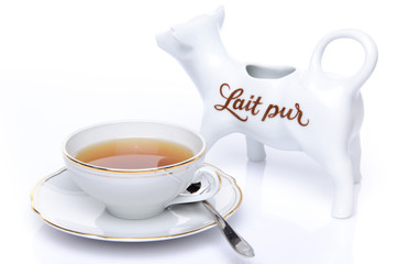 A cup of tea with a milk jug