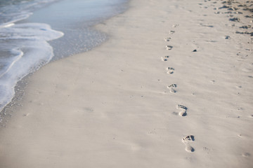 Human footprints on white sand of the Caribbean island