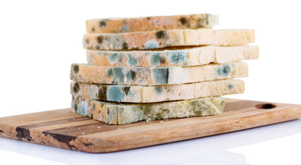 Mouldy bread on cutting board, isolated on white
